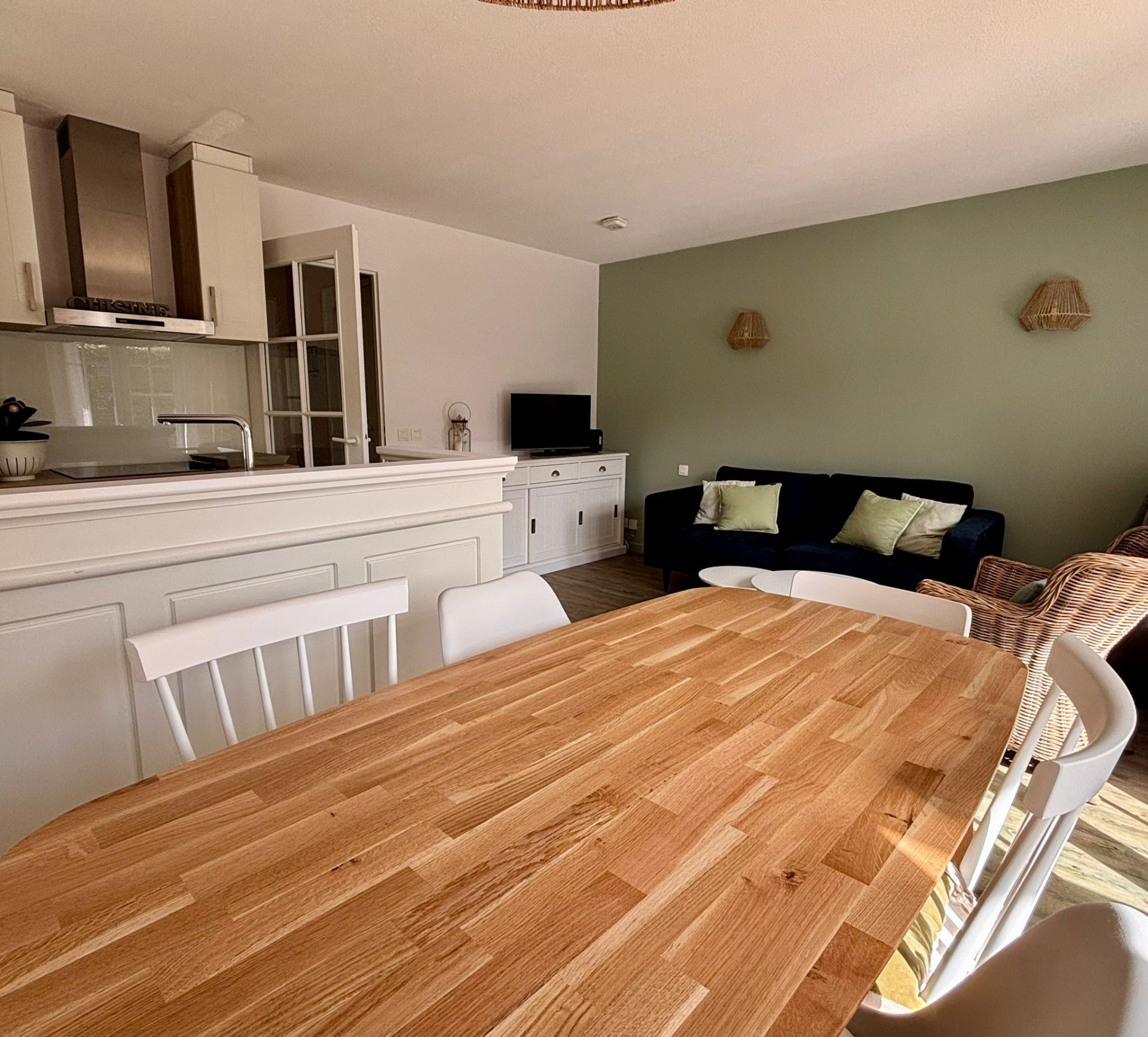 Le salon avec coin repas et coin canapé et TV